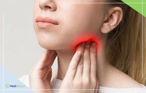 Женщина прикасается к шее, область под нижней челюстью подсвечена красным, что символизирует боль или воспаление лимфатических узлов