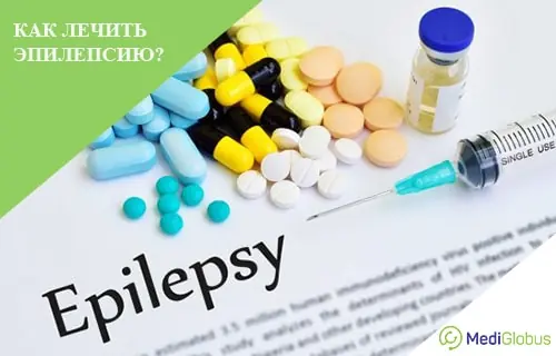 Лечение эпилепсии медикаментозно На листе бумаги с надписью «Epilepsy» расположены разноцветные таблетки, капсулы, шприц с иглой и флакон с прозрачным раствором