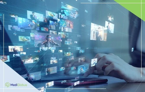 людина працює за ноутбуком, на передньому плані — проекція монітора з безліччю цифрових зображень людей