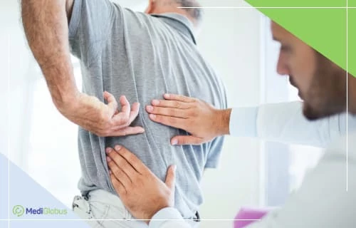 Лечение боли в спине врач проводит осмотр спины пациента, который указывает на место, где ощущает боль или дискомфорт