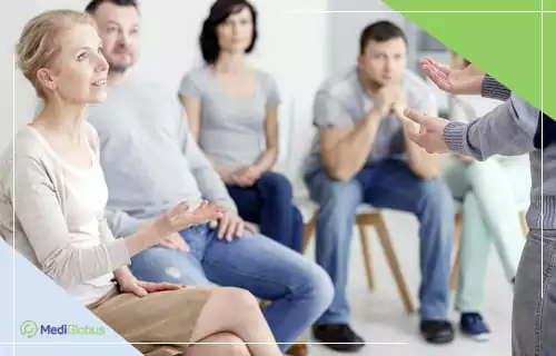 Работа психолога с родственниками онкобольного Группа людей сидит на стульях, обсуждая тему в рамках групповой консультации