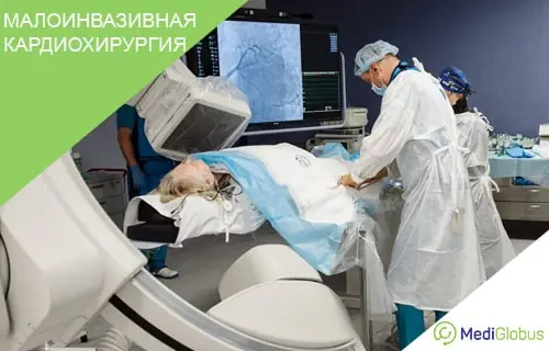 Малоинвазивная кардиохирургия Пациентка проходит малоинвазивную кардиохирургическую процедуру; она лежит на операционном столе под стерильным покрывалом, рядом врачи в защитных халатах и масках работают с рентгеноаппаратом С‑дугой, на мониторе виден ангиографический снимок сосудов сердца.