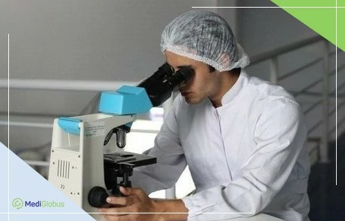 Лечение рака легких в Германии Лаборант в белом халате исследует образец под микроскопом