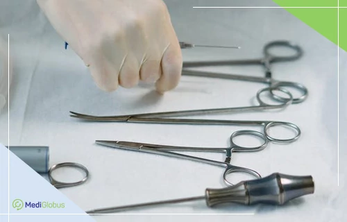 Операция при нейробластоме — подготовка хирургических инструментов хирургические инструменты на стерильной поверхности, рука в перчатке берет инструмент
