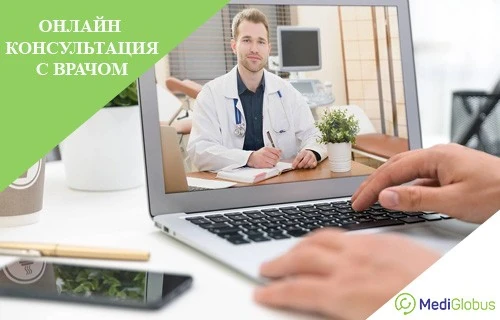Консультирование онлайн с зарубежным доктором Онлайн-консультация с врачом: на экране открытого ноутбука мужчина-врач в белом халате сидит за рабочим столом, перед ноутбуком видны руки пациента на клавиатуре