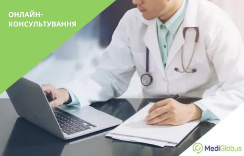 Онлайн-консультація з лікарем Лікар у білому халаті зі стетоскопом на шиї сидить за столом і працює з ноутбуком та документами