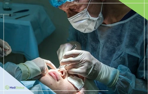 Блефаропластика в Израиле Хирург в операционной проводит процедуру на лице пациента