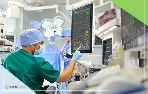 Хирурги в современной операционной проводят  операцию и контролируют показатели жизнедеятельности пациента на мониторах