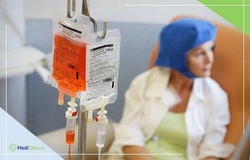 химиотерапия при лимфоме пакеты с препаратами подвешенные на капельнице, на заднем фоне сидит женщина с платком на голове