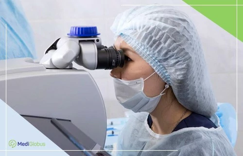 LASEK - менее травматичный метод коррекции зрения врач‑офтальмолог в стерильной одежде и маске смотрит в окуляр офтальмологического микроскопа