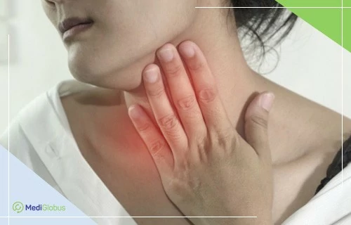 жінка торкається рукою ділянки шиї, де видно почервоніння, що символізує біль або запалення