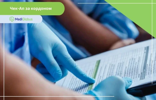 Руки в синіх медичних рукавичках тримають планшет із документом; у верхньому лівому куті — напис «Медичний огляд за кордоном»