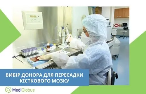 Лаборант у захисному костюмі та масці працює за стерильним столом, проводить аналіз зразків крові для підбору донора кісткового мозку