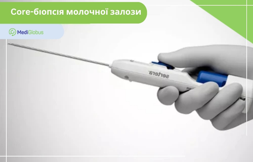 Core-біопсія молочної залози Рука в медичній рукавичці тримає білий прилад Sertera для core-біопсії молочної залози з довгою тонкою металевою голкою. У лівому верхньому куті розташована зелена табличка з написом «Core-біопсія молочної залози»